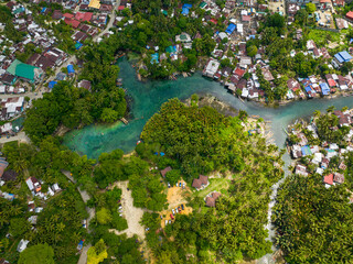 Tropical forest and clear water in cold spring. Fishermans houses and boat. Bogac Cold Spring....