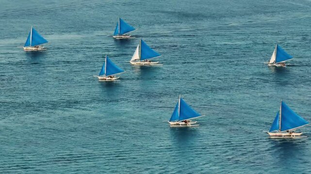 Top view of paraw sailing boats running over the turquoise water. Boracay, Philippines.