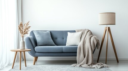 Serene living room scene with a blue sofa, lamp, side table and neutral elements