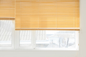 Stylish wooden blinds on window in living room