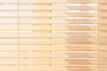 Stylish wooden blinds on window in living room, closeup