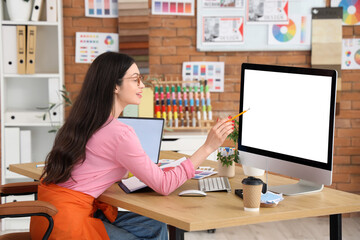 Female designer working with blank computer in office