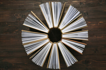 Circle made of many different books on wooden background