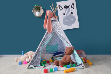 Interior of messy children's room with play tent and scattered toys