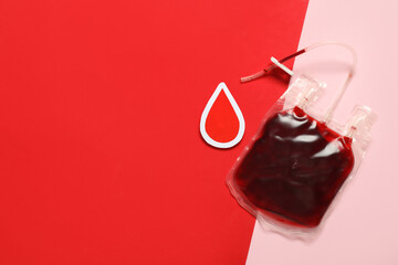 Blood pack for transfusion with paper drop on color background. Blood donation concept