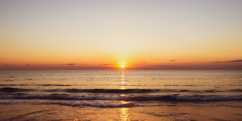 Naklejka premium Beach scene with sunrise or sunset over the ocean water.premium photo of sea and sun view for background