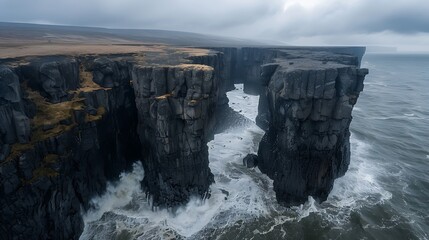 Coastal cliff landscape with massive waves crashing against rugged rocks and sea mist rising