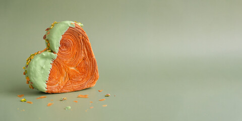 Delicious fresh croissant topped with Matcha Green Tea flavor Ganache. Creation unique heart shape bakery. Puff pastry holiday love gift present idea Valentine's day. Copy space 