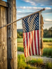 Old flag with frayed edges and faded colors hanging from a worn wooden pole