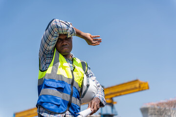 Construction Worker Shielding Eyes from Sun, Tired Construction Engineer Man Wiping Sweat Under the...