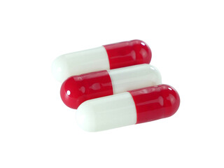 Bulk red and white capsule pills isolated on white background.