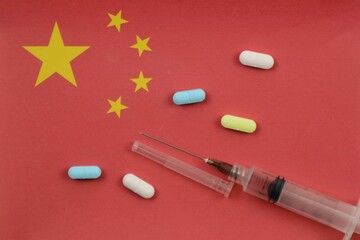 Syringe with Pills on Chinese Flag. drug trafficking and health concept