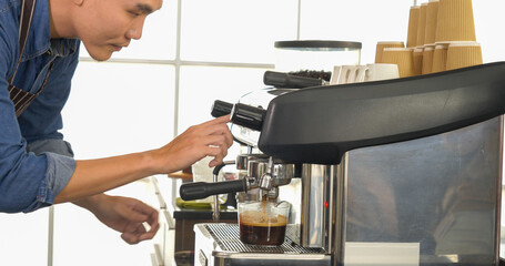 Coffee barista man make espresso shot from coffee maker hot cup. Cappuccino with milk in italian coffee shop cafe. Close up hands of barista use machine make brown latte art for customer cafeteria