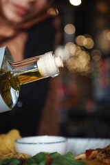 Pouring olive oil over a fresh salad at a restaurant
