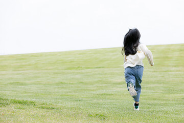 丘を駆け上る女の子の後ろ姿	