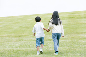 丘の上を歩く子どもの後ろ姿