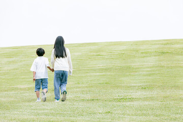 丘の上を歩く子どもの後ろ姿