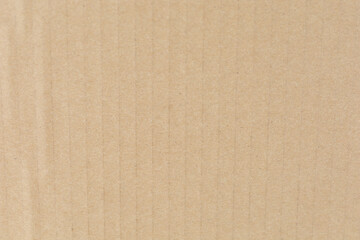 Close-up of textured beige corrugated cardboard surface, showcasing vertical ridges and subtle shading.