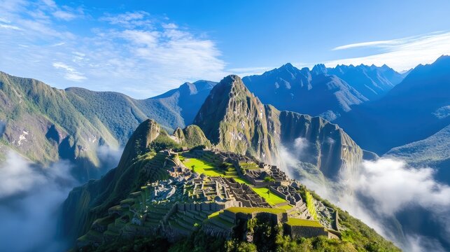 A breathtaking view of Machu Picchu nestled high in the Andes Mountains, bathed in morning light. Misty valleys and peaks surround the ancient Inca citadel
