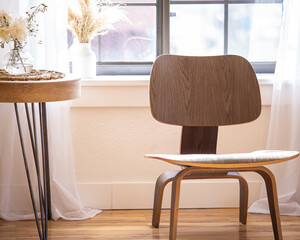 Wood chair near window with table and neutral decor