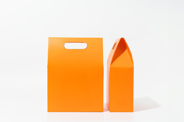 Two orange paper shopping bags on white background – front and side view