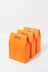 Set of three orange gift or shopping bags – clean minimalist packaging mockup