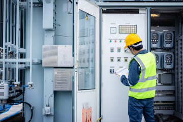 Engineer is working on high voltage power substation performing inspection and check of electrical infrastructure to ensure safety and proper operation of system