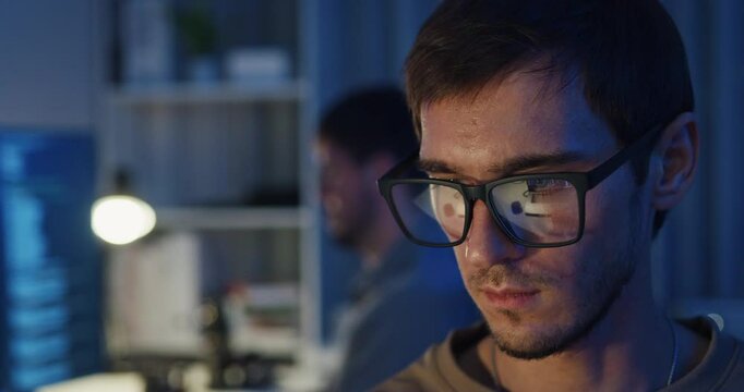 Closeup team adult male freelance work late typing write prompt AI bot app program nomad terminal code at office night. Artificial intelligence dashboard, robotics, user interface, machine learning.