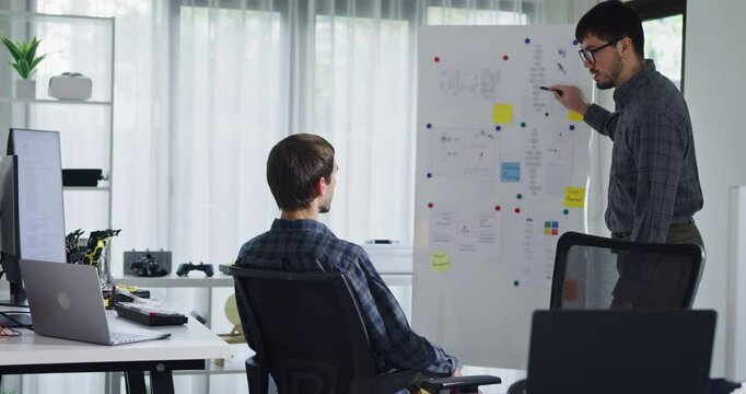 Team adult male engineer develop present AI robotics hand project at tech workspace. Artificial intelligence, collaboration support prototype development, robotic, debugging, machine learn, training.