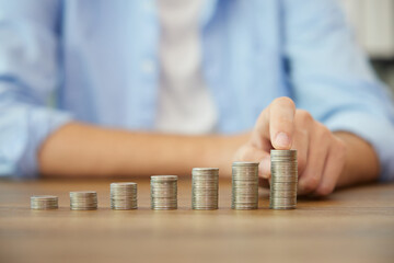 young man hands counting coins on a table for save money