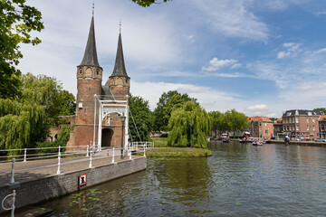 The iconic Oostpoort (Eastern Gate) in Delft, a picturesque medieval landmark with its twin spires,...