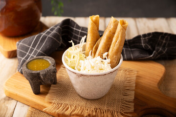 Flautas Ahogadas (Drowned Flautas) Golden tacos made with fried corn tortillas, filled with chicken...