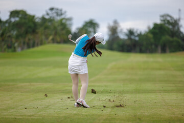 asian women swing and hitting golf ball at the golf course,