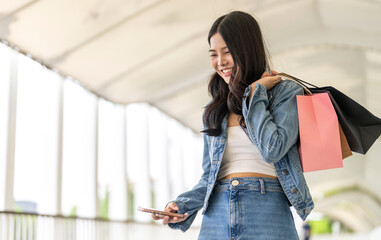Asian woman holding shopping bags excited new purchases at shopping mall, discount and promotion...