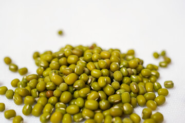 macro Close-up of Organic green Gram (Vigna radiata) or whole green moong dal cleaned on a white background. Top view