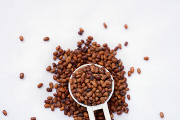 Horse gram in white spoon isolated in white background. Kulthi dal or horse gram is widely known...