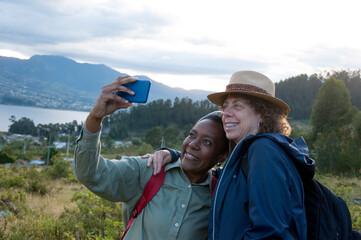 Two female tourists taking a selfie in a beautiful mountain scenery