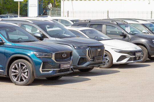 Russia, Samara. 23. 04 2025. Geely cars of the Chinese company Geely Holding are in the showroom for sale on a summer sunny day. Text in Russian: Samara auto, special price, special offer