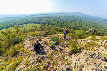 Mature tourists on the rocky peak of Yanguzey on the Irendyk ridge in the Southern Urals on a summer day © tramp51