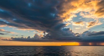 Dramatic sky with dark storm clouds over the calm ocean at sunset