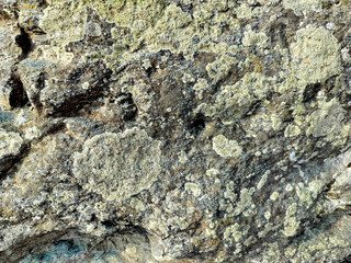 Textured stone background with rough rock wall surface, abstract natural grunge detail of stone material