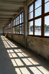 Abandoned industrial hall with old furniture, metal parts, and dusty workspaces. Atmospheric lost...
