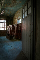 Abandoned industrial hall with old furniture, metal parts, and dusty workspaces. Atmospheric lost...