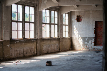 Abandoned industrial hall with old furniture, metal parts, and dusty workspaces. Atmospheric lost...