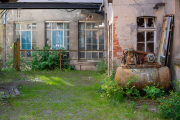 Abandoned industrial hall with old furniture, metal parts, and dusty workspaces. Atmospheric lost...
