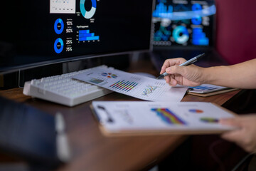 A person is writing on a piece of paper with a pen on a desk