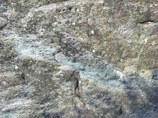 Textured stone background with rough rock wall surface, abstract natural grunge detail of stone material