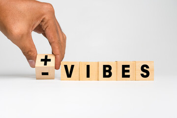 male hand flip wooden blocks with positive and negative vibes isolated on white background