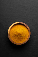 Wooden Spoons with Turmeric Powder on Slate Background – Natural Cooking Ingredients