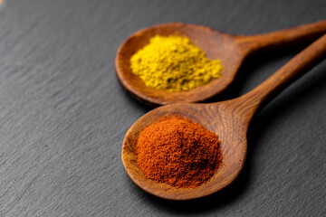 Colorful Spices on Wooden Spoons – Curry, Turmeric, and Paprika on Dark Slate Background